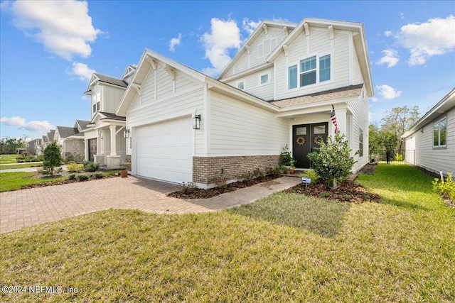 craftsman inspired home with a garage and a front lawn