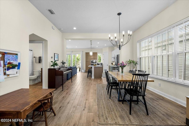 dining space featuring hardwood / wood-style flooring, a chandelier, and a textured ceiling