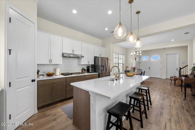 kitchen featuring stainless steel appliances, white cabinets, hardwood / wood-style floors, and sink