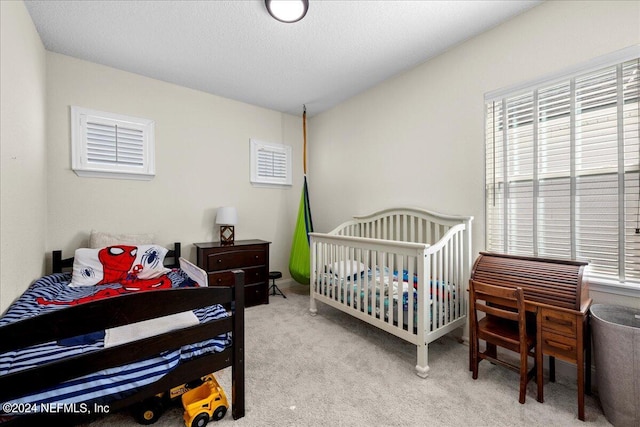 bedroom featuring light colored carpet and a textured ceiling