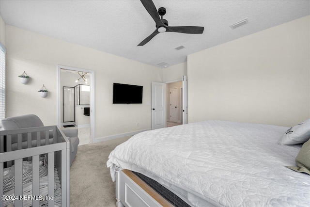 carpeted bedroom featuring connected bathroom, a textured ceiling, and ceiling fan