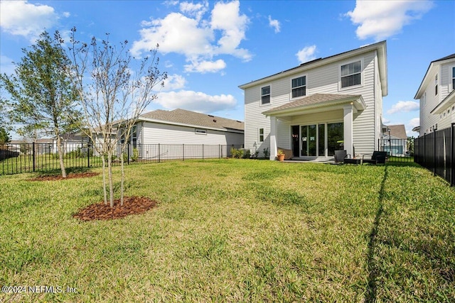 rear view of property with a lawn and a patio