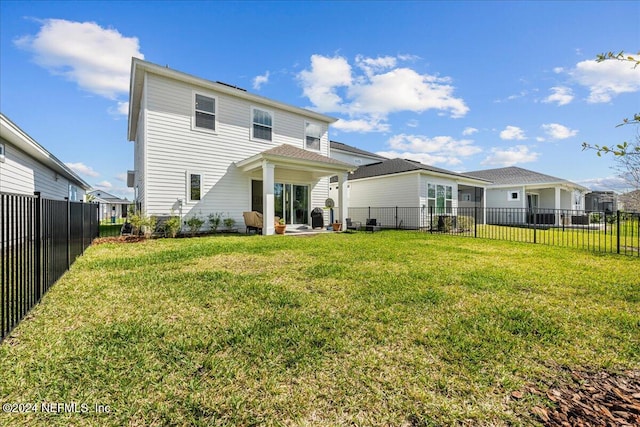 rear view of property with a patio and a yard