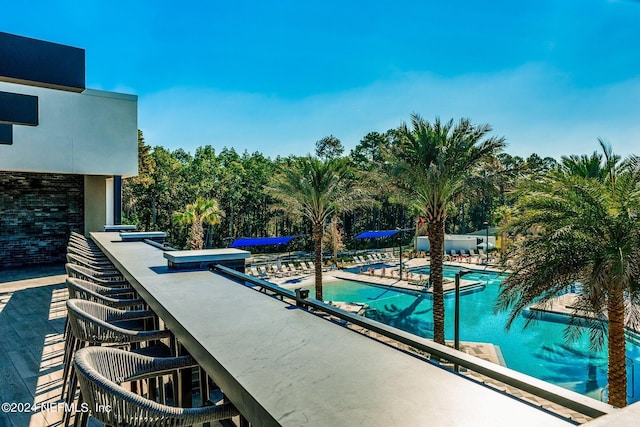 view of pool featuring exterior bar and a patio area