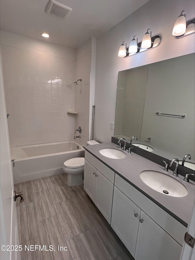 full bathroom with tiled shower / bath combo, toilet, and vanity