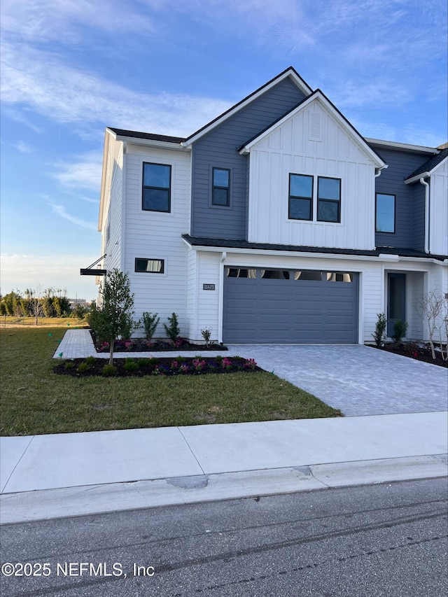 modern farmhouse with a front lawn and a garage