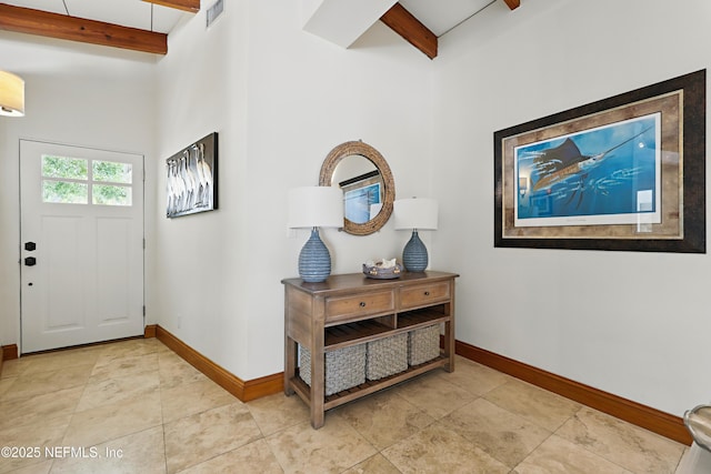 entrance foyer with light tile patterned floors, baseboards, visible vents, and beam ceiling