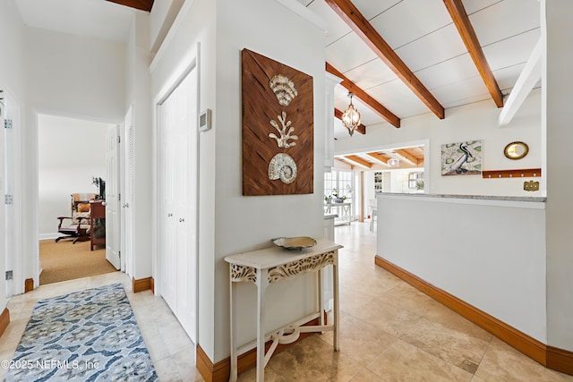 hallway with baseboards, light tile patterned floors, and beam ceiling