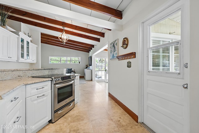 kitchen featuring glass insert cabinets, plenty of natural light, lofted ceiling with beams, and stainless steel electric range
