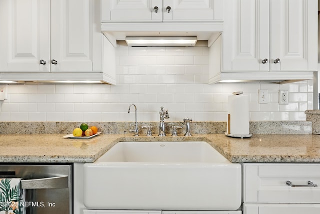 kitchen featuring light stone counters, a sink, white cabinetry, tasteful backsplash, and stainless steel dishwasher