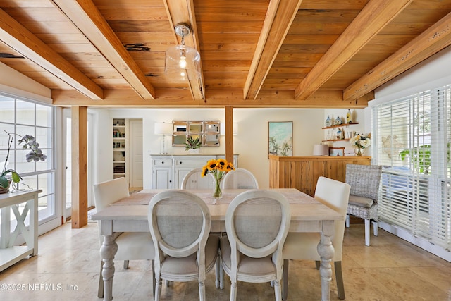 dining area with wooden ceiling, beam ceiling, and a wealth of natural light