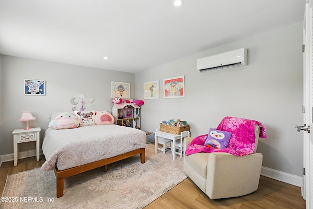 bedroom with recessed lighting, baseboards, a wall unit AC, and wood finished floors