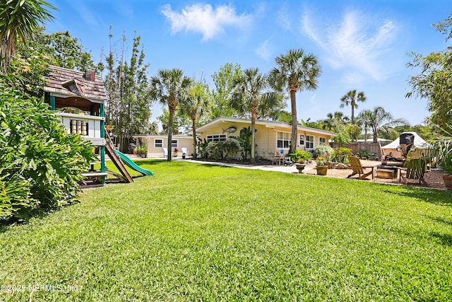 view of yard featuring a playground, a patio area, and fence