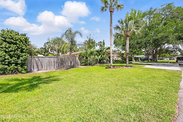 view of yard featuring fence and driveway