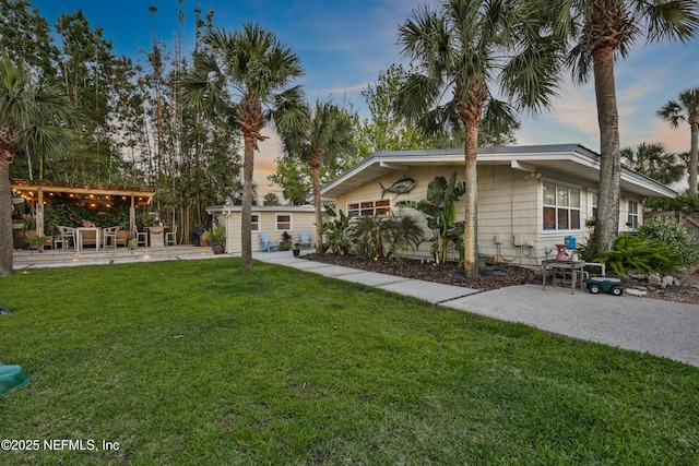 exterior space featuring a lawn, an outdoor structure, and a patio area