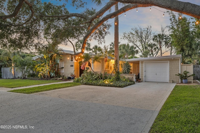 single story home with a garage, fence, driveway, and a front lawn