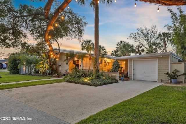 view of front of property with an attached garage, a front lawn, and driveway