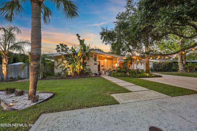 view of front of home with fence and a front lawn