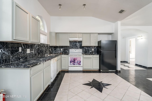 kitchen with tile patterned flooring, tasteful backsplash, white appliances, sink, and lofted ceiling