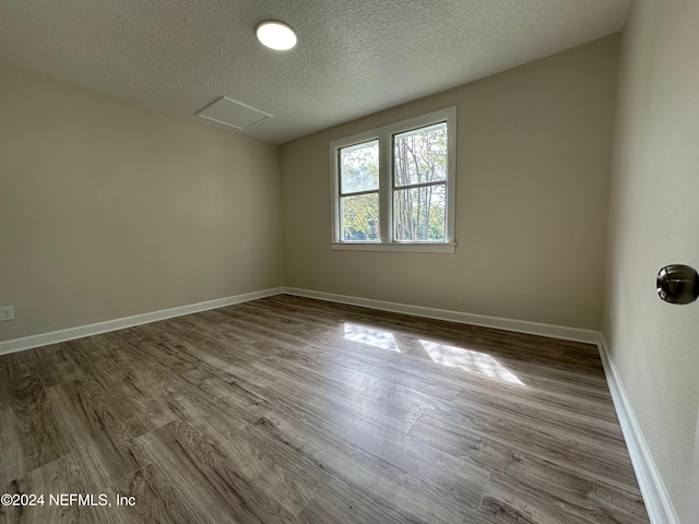 spare room with hardwood / wood-style flooring and a textured ceiling