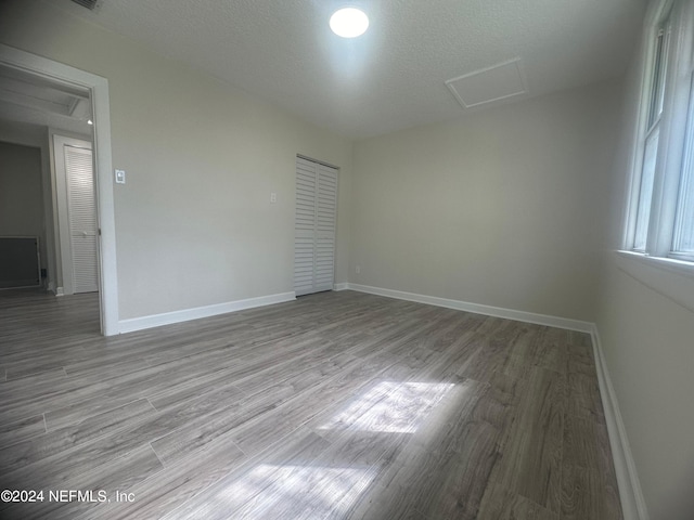 spare room featuring light hardwood / wood-style flooring and a textured ceiling