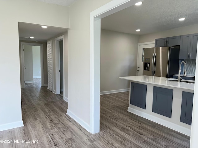 kitchen with dark wood-type flooring, stainless steel fridge, sink, and gray cabinetry