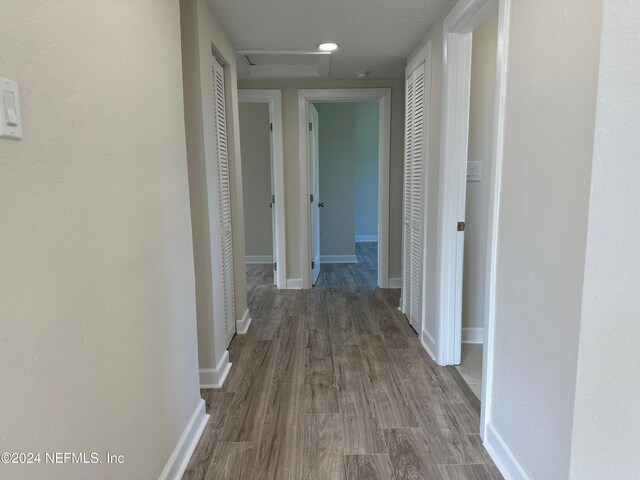 hallway with dark wood-type flooring and a textured ceiling