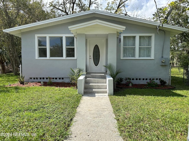 bungalow-style home featuring a front lawn