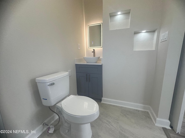 bathroom featuring vanity, tile patterned flooring, and toilet