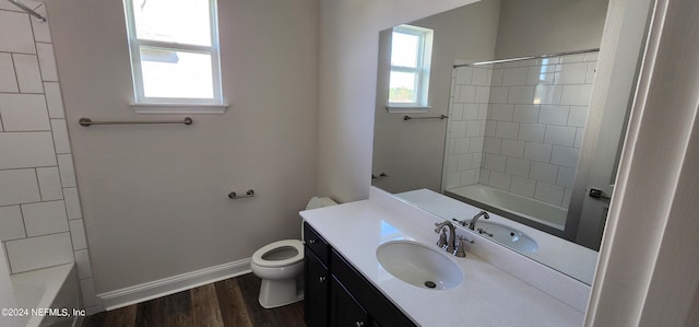 full bathroom featuring tiled shower / bath, hardwood / wood-style flooring, vanity, and toilet