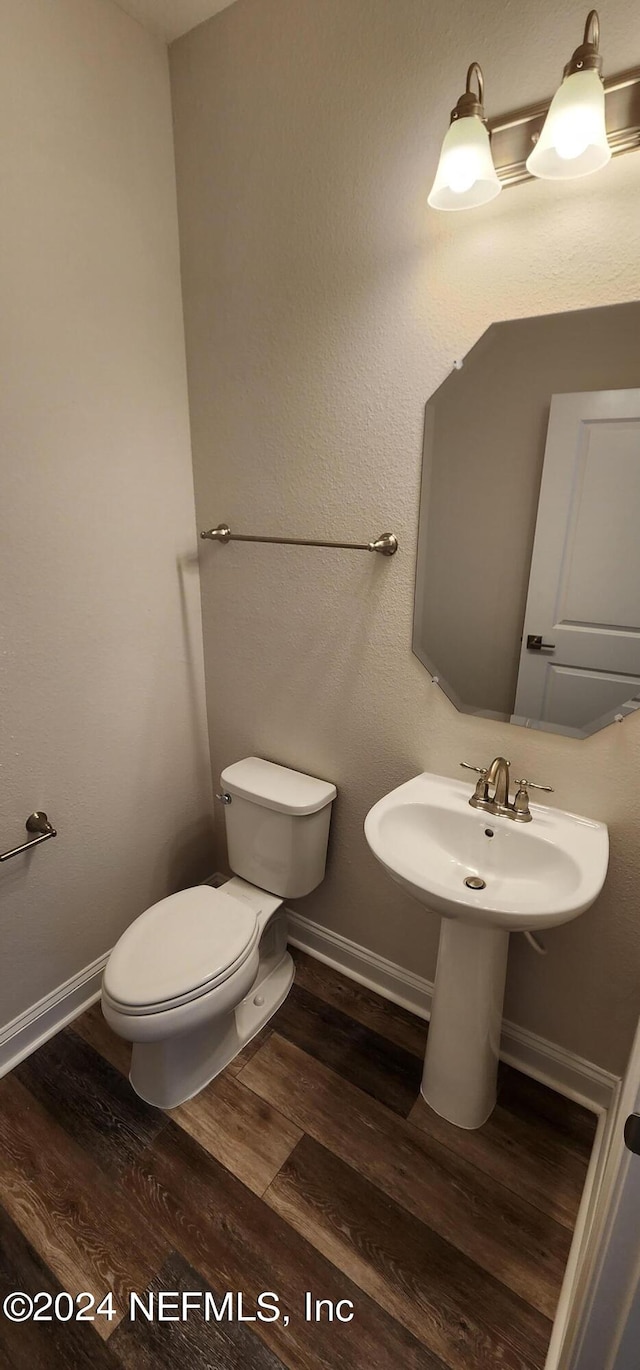 bathroom featuring wood-type flooring and toilet