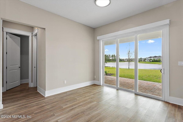 empty room featuring light hardwood / wood-style flooring and a water view