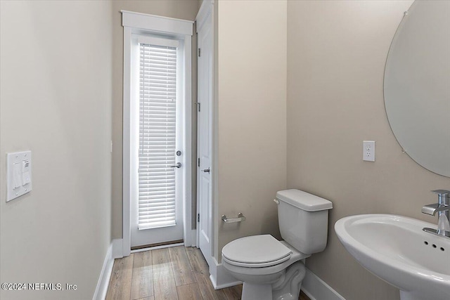 bathroom with sink, hardwood / wood-style floors, a wealth of natural light, and toilet