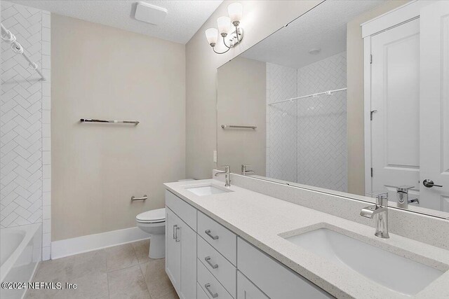 bathroom featuring a textured ceiling, tile patterned floors, vanity, and toilet