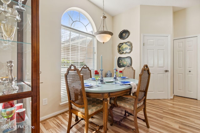 dining area with lofted ceiling and light hardwood / wood-style floors