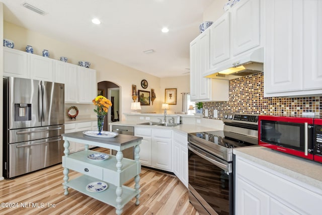 kitchen with sink, appliances with stainless steel finishes, white cabinetry, and light hardwood / wood-style floors