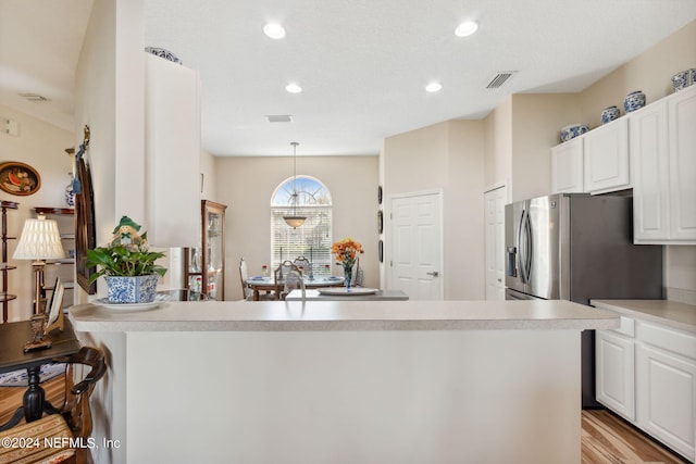 kitchen featuring white cabinetry, light hardwood / wood-style flooring, and pendant lighting