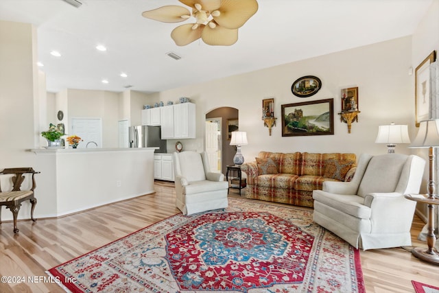 living room featuring light hardwood / wood-style flooring and ceiling fan