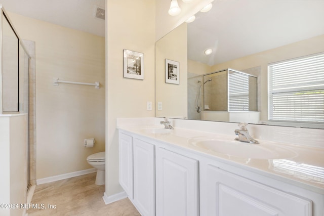 bathroom with a shower with door, vanity, toilet, and tile patterned flooring