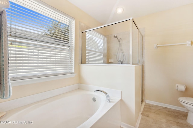 bathroom featuring shower with separate bathtub and toilet