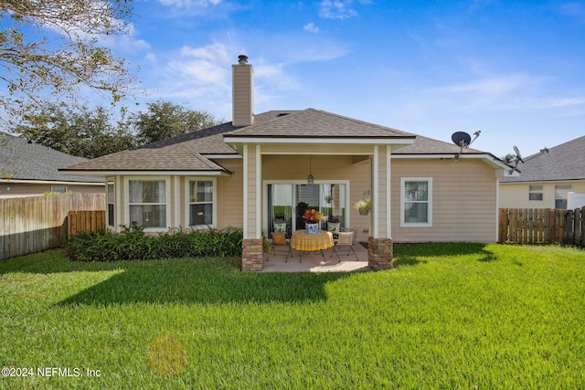 rear view of property with a patio area, a lawn, and ceiling fan