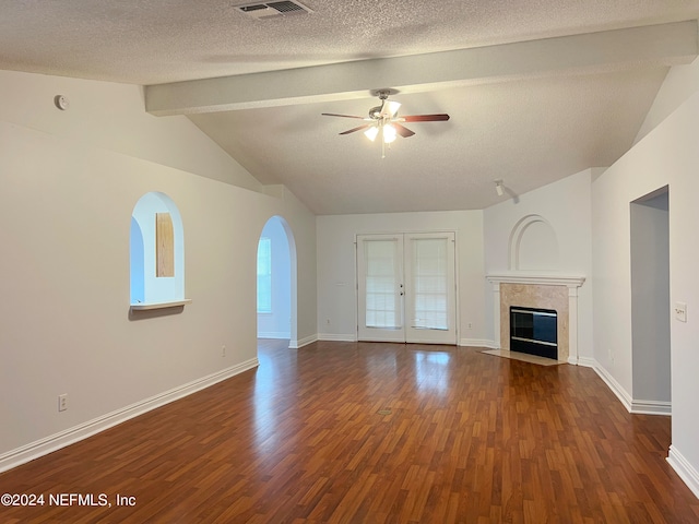 unfurnished living room with ceiling fan, lofted ceiling with beams, a textured ceiling, and dark hardwood / wood-style floors