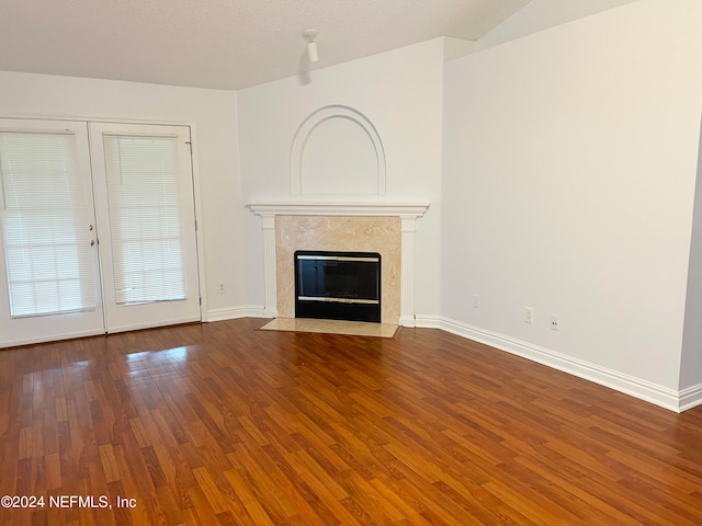 unfurnished living room featuring a high end fireplace, a textured ceiling, wood-type flooring, and french doors