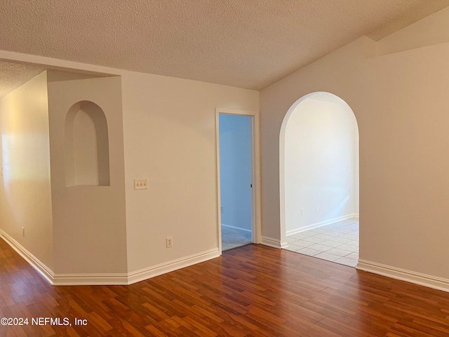 unfurnished room featuring hardwood / wood-style floors and a textured ceiling