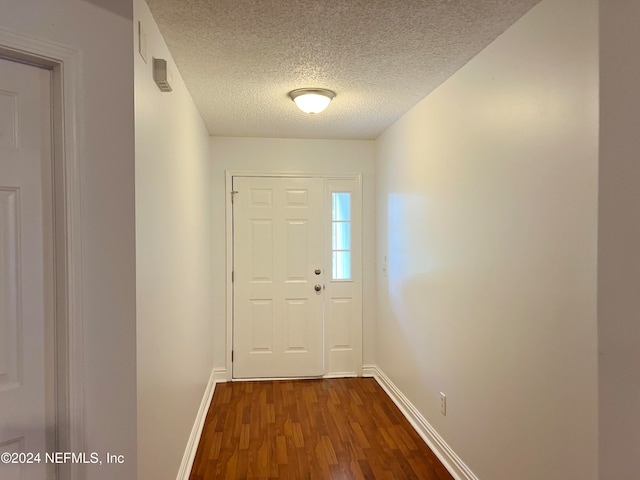 entryway with a textured ceiling and dark hardwood / wood-style flooring