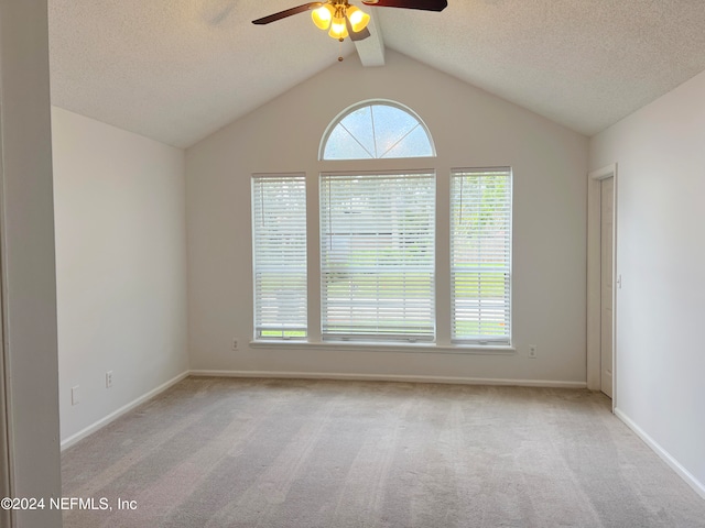 carpeted spare room featuring lofted ceiling with beams, a textured ceiling, and ceiling fan