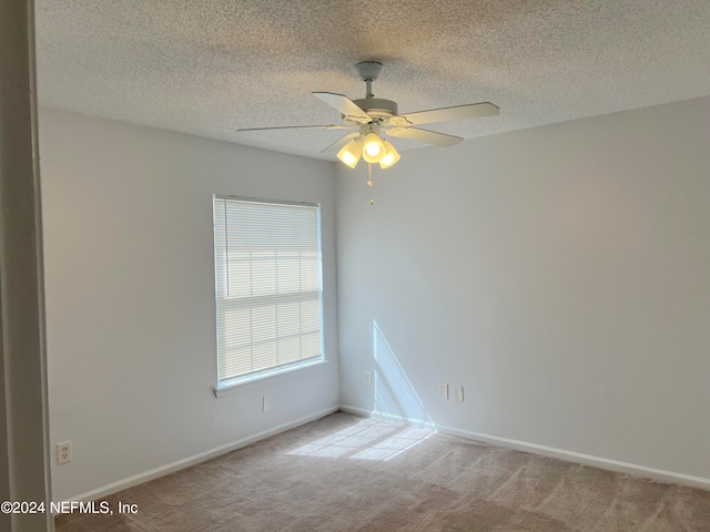 carpeted spare room featuring ceiling fan and a textured ceiling