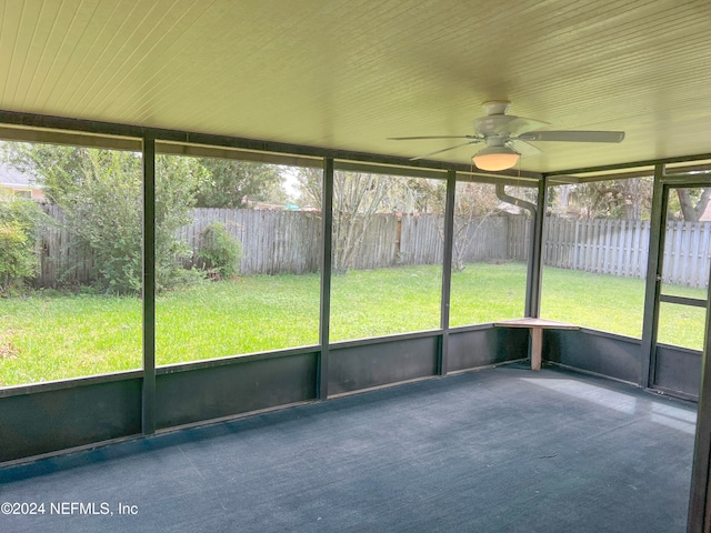 unfurnished sunroom featuring ceiling fan and a wealth of natural light