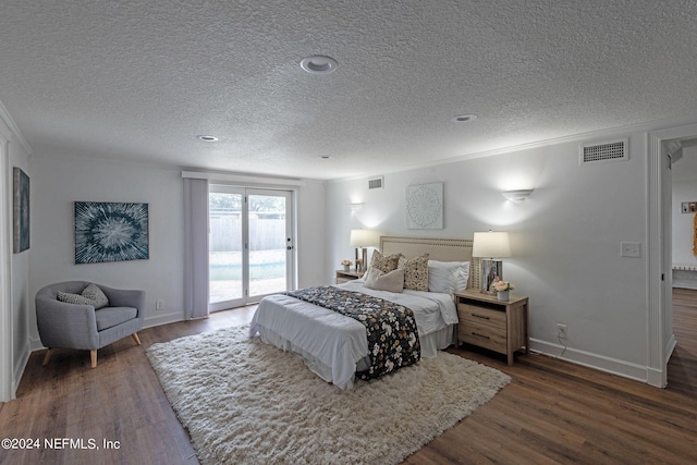 bedroom with ornamental molding, a textured ceiling, access to outside, and dark hardwood / wood-style flooring