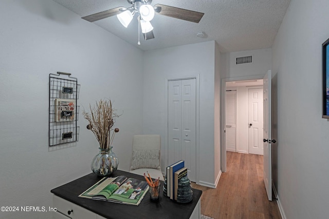 office area featuring light hardwood / wood-style floors, a textured ceiling, and ceiling fan